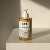 Cole shower gel bottle on a beige surface with a neutral background
