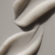 Close-up of smooth, white cream on a neutral background