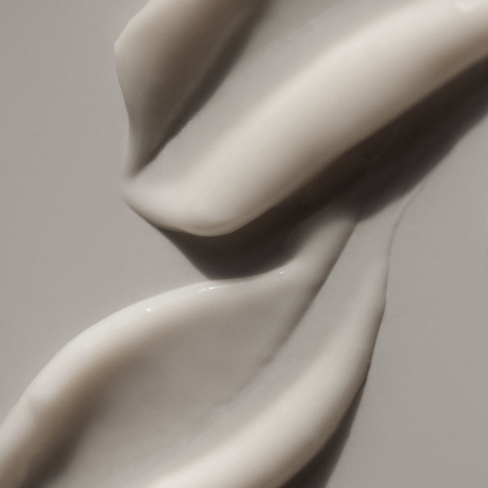 Close-up of smooth, white cream on a neutral background