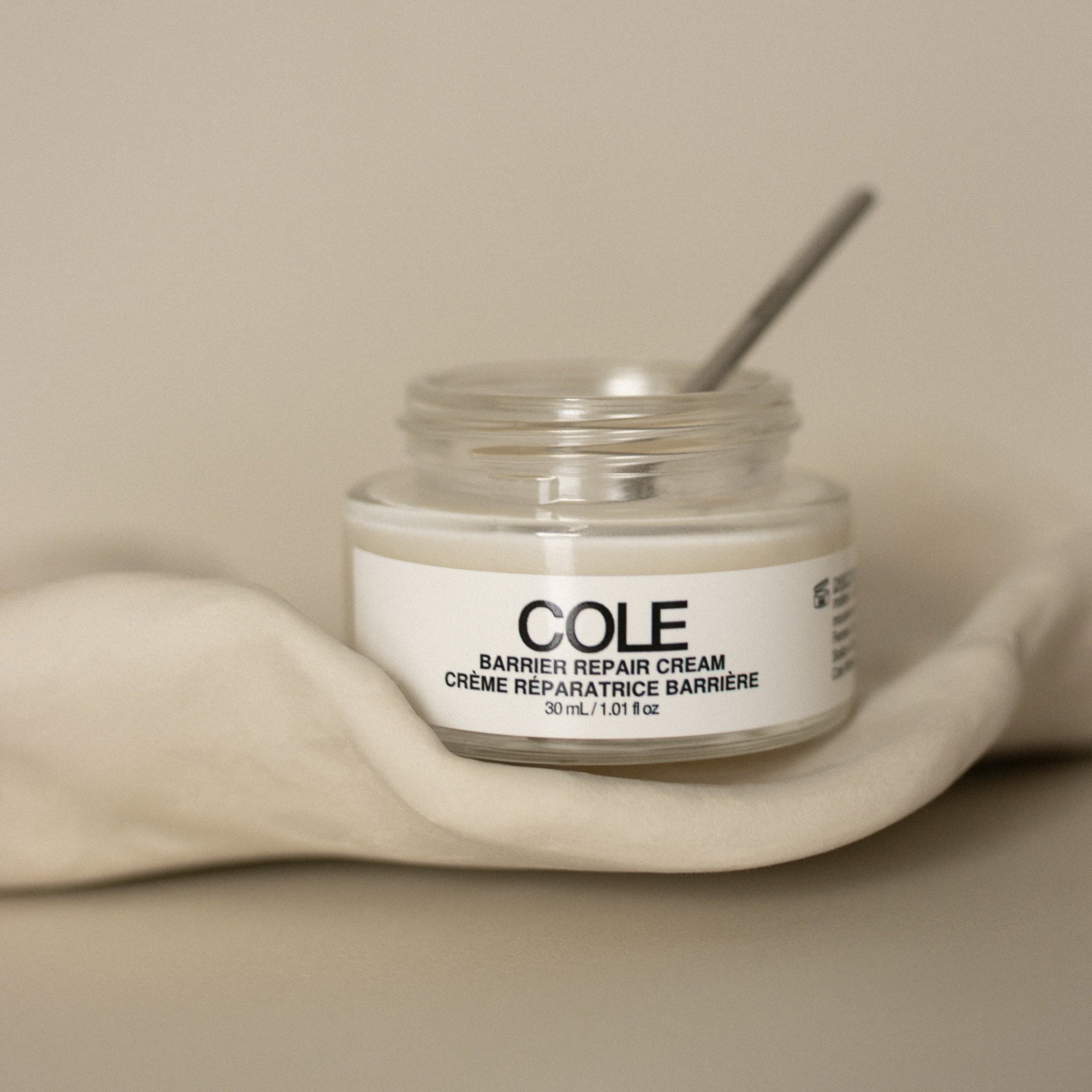 Jar of COLE Barber Repair Cream on a beige background