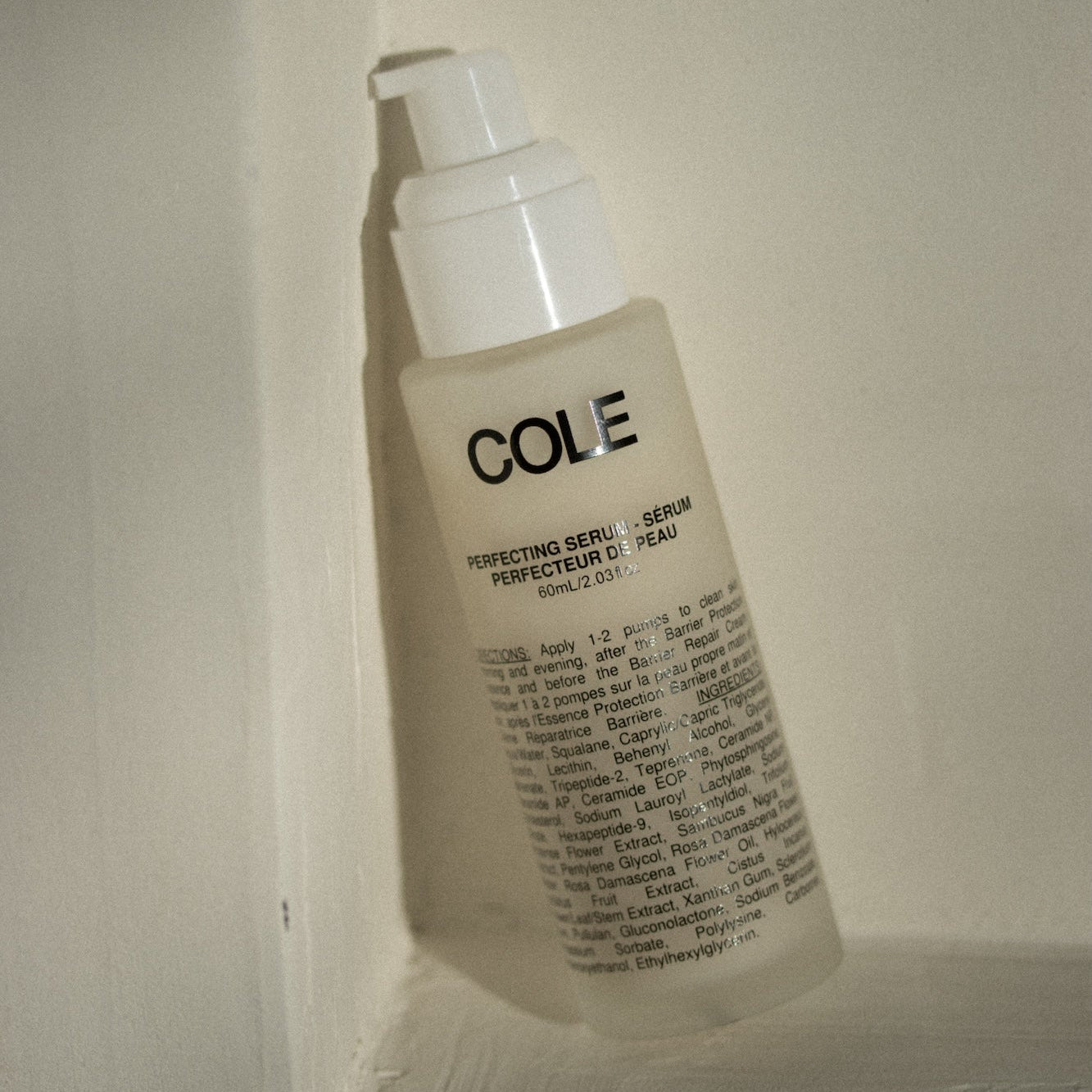 Skincare serum bottle labeled 'COLE' on a neutral background