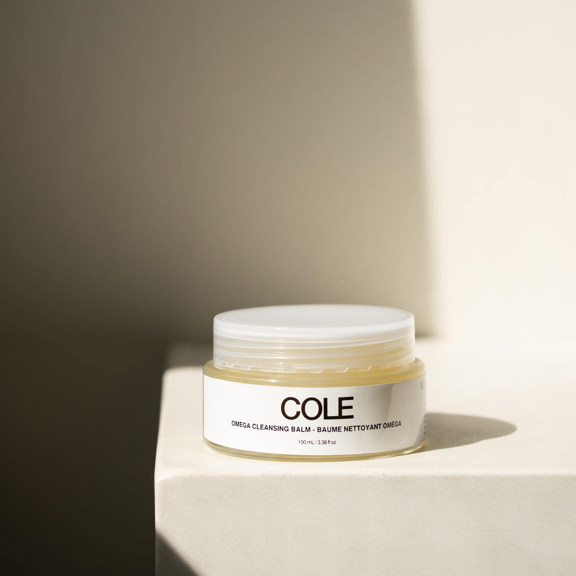 Jar of COLE product on a light surface with a neutral background